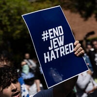 Un manifestant tenant une affiche sur laquelle on peut lire "End Jew Hatred", sur le campus de l'Université de Californie (UCLA), à Los Angeles, le 28 avril 2024. (Crédit : Etienne Laurent/AFP)