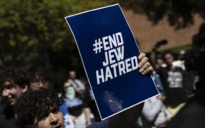 Un manifestant tenant une affiche sur laquelle on peut lire "End Jew Hatred", sur le campus de l'Université de Californie (UCLA), à Los Angeles, le 28 avril 2024. (Crédit : Etienne Laurent/AFP)
