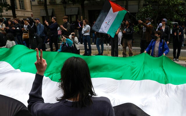 Illustration : Des étudiants arborant un drapeau "palestinien" géant alors qu'ils participent à un rassemblement anti-Israël, à la Sorbonne, à Paris, le 29 avril 2024. (Crédit : Geoffroy Van Der Hasselt/AFP)