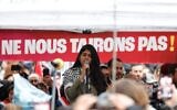 L'activiste controversée Rima Hassan s'adressant à la foule lors d'un rassemblement « contre la criminalisation des voix de la paix » organisé par LFI, suite à une convocation de la police contre Hassan et une autre membre du parti, à Paris, le 30 avril 2024. (Crédit : Geoffroy Van Der Hasselt/AFP)