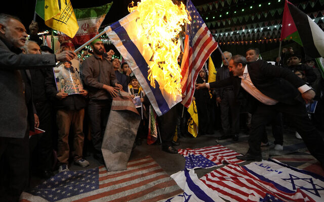 Des manifestants iraniens brûlant des représentations de drapeaux américain et israélien lors d'un rassemblement visant à condamner l'assassinat de membres des Gardiens de la Révolution islamique, en Syrie, sur la place Felestin (Palestine) dans le centre de Téhéran, le 1er avril 2024. (Crédit : Vahid Salemi/AP Photo) Des manifestants iraniens brûlant des représentations de drapeaux américain et israélien lors d'un rassemblement visant à condamner l'assassinat de membres des Gardiens de la Révolution islamique, en Syrie, sur la place Felestin (Palestine) dans le centre de Téhéran, le 1er avril 2024. (Crédit : Vahid Salemi/AP Photo)