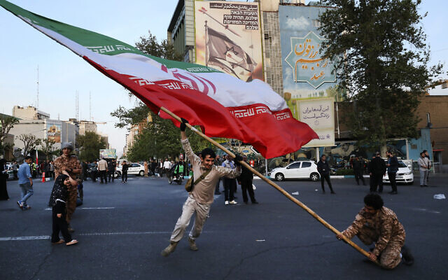 Des manifestants brandissant un immense drapeau iranien à Téhéran, en Iran, le 15 avril 2024. (Crédit : Vahid Salemi/AP) Des manifestants brandissant un immense drapeau iranien à Téhéran, en Iran, le 15 avril 2024. (Crédit : Vahid Salemi/AP)