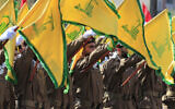Illustration : Des terroristes du Hezbollah brandissant des drapeaux du groupe terroriste chiite libanais lors des funérailles d'un commandant et d'un autre terroriste qui ont été tués par une frappe de drone israélienne, dans le village de Chehabiyeh, au sud-Liban, le 17 avril 2024. (Crédit : Mohammed Zaatari/AP)