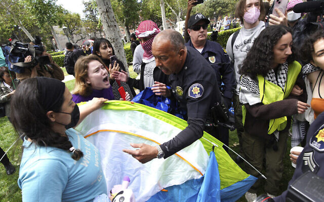 Des manifestants de l'Université de Californie du Sud se battent avec des agents de la sécurité publique de l'université qui tentent de retirer les tentes du parc des anciens élèves suite à un mouvement d'occupation pro-palestinien et anti-Israël, à Los Angeles, le 24 avril 2024. (Crédit : Richard Vogel/AP)