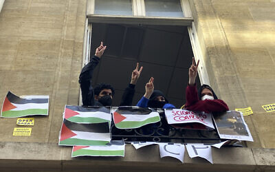 Des étudiants pro-palestiniens et anti-Israël bloquant l'université de Sciences-Po font le signe de la victoire, à Paris, le 26 avril 2024. (Crédit : Jeffrey Schaeffer/AP)