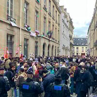 Des agents de police regardent les étudiants aux abords de l'université de Sciences-Po, le 26 avril 2024. (Crédit : AP Photo/Jeffrey Schaeffer)