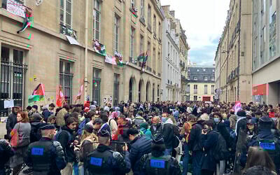 Des agents de police regardent les étudiants aux abords de l'université de Sciences-Po, le 26 avril 2024. (Crédit : AP Photo/Jeffrey Schaeffer)