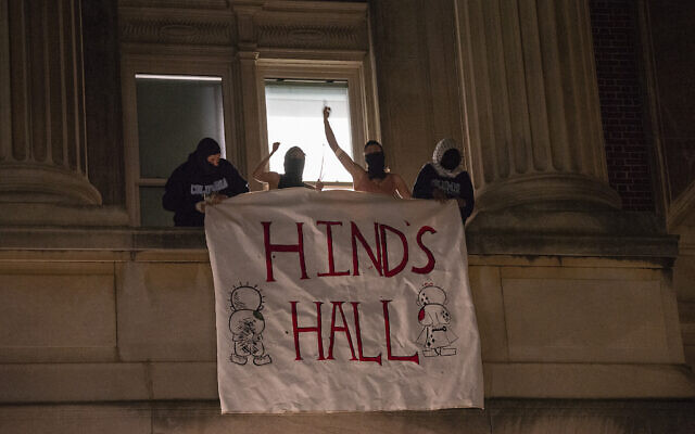 Des manifestants anti-Israël du campus de l'Université de Columbia déployant une banderole alors qu'ils se barricadent à l'intérieur du Hamilton Hall, qui porte le nom d'un enfant palestinien prétendument tué par Israël à Gaza dans le cadre de la guerre en cours contre le Hamas, à New York, le 30 avril 2024. (Crédit : Marco Postigo Storel/AP) Des manifestants anti-Israël du campus de l'Université de Columbia déployant une banderole alors qu'ils se barricadent à l'intérieur du Hamilton Hall, qui porte le nom d'un enfant palestinien prétendument tué par Israël à Gaza dans le cadre de la guerre en cours contre le Hamas, à New York, le 30 avril 2024. (Crédit : Marco Postigo Storel/AP)