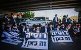 Des Juifs ultra-orthodoxes bloquent une route et affrontent la police pendant une manifestation contre le service militaire obligatoire sur la Route 4, aux abords de Bnei Brak, le 1er avril 2024. (Crédit : Chaim Goldberg/Flash90)