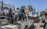 Des Palestiniens armés et masqués sur des camions chargés d'aide humanitaire internationale entrant dans Gaza par le point de passage israélien de Kerem Shalom, dans le sud de Gaza, le 3 avril 2024. (Crédit : Abed Rahim Khatib/Flash90)