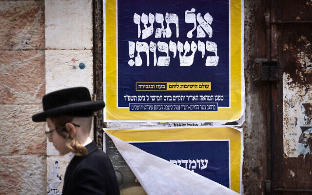Photo d'illustration : Un Juif ultra-orthodoxe passe devant une affiche contre le service militaire des Haredim. On peut y lire : « Ne touchez pas aux yeshivot », dans le quartier ultra-orthodoxe de Mea Shearim, à Jérusalem, le 9 avril 2024. (Crédit : Chaim Goldberg/Flash90) Photo d'illustration : Un Juif ultra-orthodoxe passe devant une affiche contre le service militaire des Haredim. On peut y lire : « Ne touchez pas aux yeshivot », dans le quartier ultra-orthodoxe de Mea Shearim, à Jérusalem, le 9 avril 2024. (Crédit : Chaim Goldberg/Flash90)