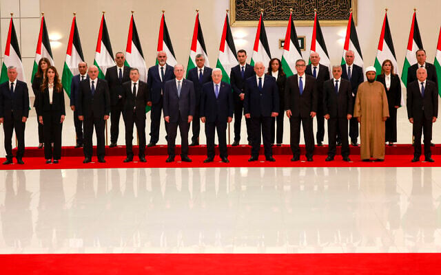 Le Président de l'Autorité palestinienne Mahmoud Abbas (au centre) et son nouveau gouvernement, après avoir prêté serment, Omar Bitar, ministre des Finances (3ᵉ à partir de la gauche – premier rang), à Ramallah, en Cisjordanie, le 31 mars 2024. (Crédit : Jaafar Ashtiyeh/AFP)