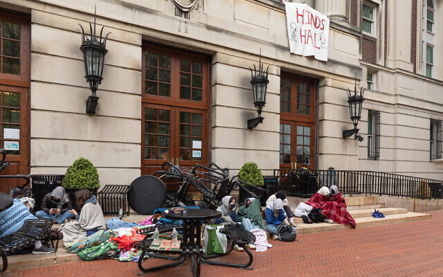 Des manifestants étudiants anti-Israël assis devant le Hamilton Hall occupé de l'université Columbia, à New York, le 30 avril 2024. (Crédit : Emily Byrski/AFP)