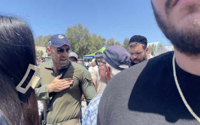 Un volontaire de la sécurité hurle sur un manifestant à l'extérieur du cimetière militaire d'Ashdod le 13 mai 2024. (Crédit : Sam Sokol/Times of Israel)