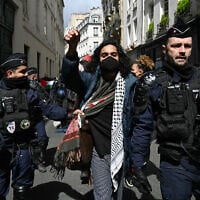 Un manifestant pro-palestinien est escorté par des gendarmes français lors de l'évacuation d'un sit-in dans le hall d'entrée de l'Institut d'études politiques (Sciences Po Paris), à Paris, le 3 mai 2024. (Crédit : Miguel Medina/AFP)
