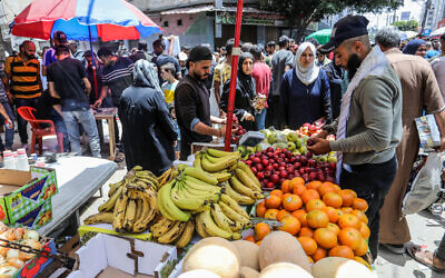 Des Palestiniens de la bande de Gaza font leurs courses sur un marché à Deir al-Balah, dans le centre de la bande de Gaza, le 23 mai 2024. (Crédit : Abed Rahim Khatib/Flash90)