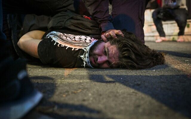 Un manifestant est maintenu au sol par un policier lors d'une manifestation contre la guerre à Gaza, dans la ville de Haïfa, au nord d'Israël, le 30 mai 2024. (Crédit : Flash90) Un manifestant est maintenu au sol par un policier lors d'une manifestation contre la guerre à Gaza, dans la ville de Haïfa, au nord d'Israël, le 30 mai 2024. (Crédit : Flash90)
