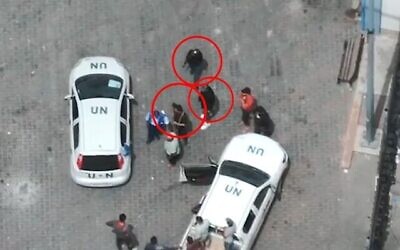 Des terroristes armés palestiniens à côté de véhicules de l'ONU dans un centre logistique de l'UNRWA à Rafah, ville la plus au sud de Gaza, sur une capture d'écran de drone publiées le 14 mai 2024. (Crédit : Armée israélienne)