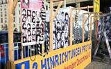 Des portraits exposés derrière un nœud coulant alors qu'une pancarte indique « Les exécutions quotidiennes » devant la porte de Brandebourg lors d'une manifestation de partisans du Conseil national de la Résistance iranienne, à Berlin, en Allemagne, le 10 février 2024. (Crédit : Stefanie Loos/AFP)