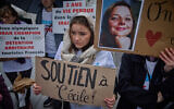Une femme, tenant une photo de l'enseignante française Cécile Kohler, détenue en Iran depuis mai 2022 avec son compagnon Jacques Paris, participe à un rassemblement place de la République à Paris, le 23 mars 2024, pour soutenir et demander la libération des citoyens français détenus en Iran. (Crédit : Kiran Ridley/AFP)