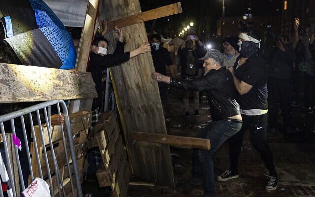 Des contre-manifestants attaquant un campement anti-Israël installé sur le campus de l'Université de Californie à Los Angeles (UCLA) alors que des affrontements éclatent, à Los Angeles, le 1er mai 2024. (Crédit : Etienne Laurent/AFP) Des contre-manifestants attaquant un campement anti-Israël installé sur le campus de l'Université de Californie à Los Angeles (UCLA) alors que des affrontements éclatent, à Los Angeles, le 1er mai 2024. (Crédit : Etienne Laurent/AFP)