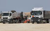 Des travailleurs déchargeant un camion à Beit Hanoun, dans le nord de la bande de Gaza, de l'aide humanitaire livrée par la Jordanie au territoire côtier par le biais du poste frontière d'Erez avec Israël, le 1er mai 2024. (Crédit : Jack Guez/AFP)
