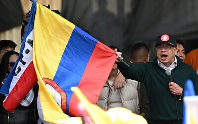 Le président colombien Gustavo Petro brandit un drapeau national alors qu'il prononce un discours lors d'un rassemblement du 1er mai (fête du Travail) à Bogota le 1er mai 2024. (Crédit : Raul ARBOLEDA / AFP)