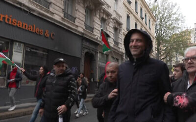Le principal candidat aux élections européennes du Parti socialiste français (PS) et du parti Place Publique, l'eurodéputé Raphaël Glucksmann (2e à droite), empêché de rejoindre le rassemblement du 1er mai , marquant la Journée internationale des travailleurs, après que des militants lui ont jeté de la peinture et crié dessus, à Saint-Etienne, le 1er mai 2024. (Crédit : Capture d'écran d'une vidéo d'AFP TV)