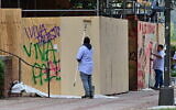 Des ouvriers nettoient des graffitis anti-israéliens sur le campus de l'Université de Californie à Los Angeles (UCLA) après que la police a expulsé des manifestants pro-palestiniens, le 2 mai 2024. (Crédit : Frederic J. Brown/AFP)
