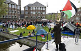 Des étudiants anti-Israël brandissant des drapeaux palestiniens et des pancartes alors qu'ils occupent le campus de l'Université d'Amsterdam, le 6 mai 2024. (Crédit : Nick Gammon/AFP)