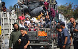 Des Palestiniens déplacés, suite à un ordre d'évacuation donné par l'armée israélienne la veille, fuyant Rafah avec leurs biens vers des zones plus sûres dans le sud de la bande de Gaza le 7 mai 2024. (Crédit : AFP)