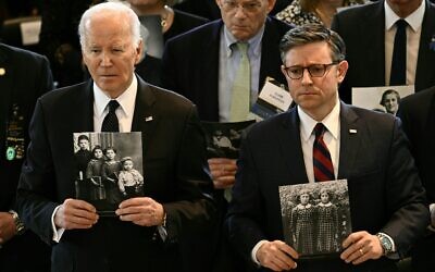 Le président américain Joe Biden (à gauche) et le président de la Chambre des représentants Mike Johnson tenant des images de victimes de la Shoah lors de la cérémonie annuelle de la Journée de commémoration des survivants de la Shoah, au Capitole américain, à Washington, le 7 mai 2024. (Credit : Brendan Smialowski/AFP)