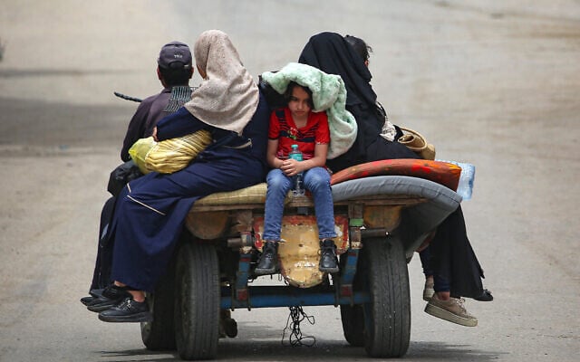 Des Palestiniens, sur une charrette, se rendent dans un secteur plus sûr de Gaza à Rafah, le 10 mai 2024. (Crédit : AFP)