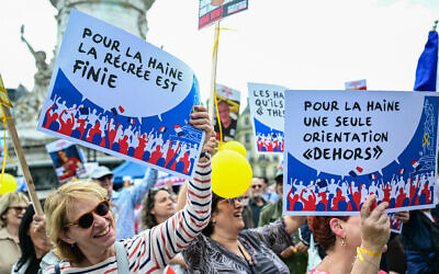 Des manifestants brandissant des pancartes sur lesquelles on peut lire « pour la haine la récréation est finie “ et ” pour la haine, une seule direction, dehors “ lors de la manifestation ” Libérons l'école de la haine » organisée par l'association Diaspora Defense Forces (DDF) Place de la Republique, à Paris, le 12 mai 2024. (Crédit : Miguel Medina/AFP)