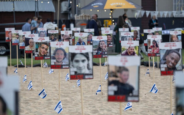 Illustration : Des photos d'otages enlevés par le Hamas, à Johannesburg le 13 mai 2024 lors de la célébration de Yom HaAtsmaout, la fête nationale israélienne commémorant le 76e anniversaire de la création de l'État d'Israël le 14 mai 1948. (Crédit : Wikus de Wet / AFP)