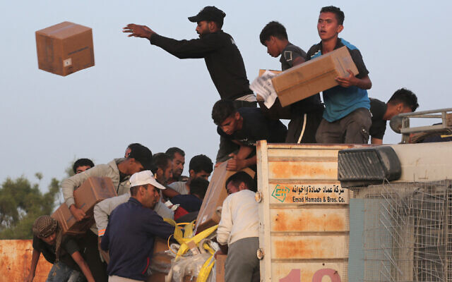 Illustration - Des Palestiniens transportant des boîtes d'aide humanitaire après s'être précipités sur les camions d'aide internationale depuis le quai Trident construit par les États-Unis non loin de Nuseirat, dans le centre de la bande de Gaza, le 18 mai 2024. Crédit : AFP) Illustration - Des Palestiniens transportant des boîtes d'aide humanitaire après s'être précipités sur les camions d'aide internationale depuis le quai Trident construit par les États-Unis non loin de Nuseirat, dans le centre de la bande de Gaza, le 18 mai 2024. Crédit : AFP)