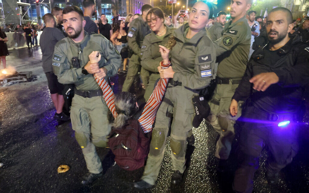 La police arrête une manifestante pendant un rassemblement des proches et des soutiens des otages à Gaza à Tel Aviv, le 26 mai 2024. (Crédit : JACK GUEZ / AFP)