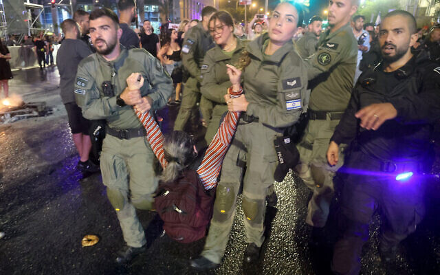 La police arrête une manifestante pendant un rassemblement des proches et des soutiens des otages à Gaza à Tel Aviv, le 26 mai 2024. (Crédit : JACK GUEZ / AFP)