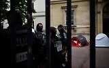 Des policiers évacuant des étudiants activistes anti-Israël occupant la cour principale de l'École Normale Supérieure (ENS), 45 rue d'Ulm, à Paris, le 26 mai 2024. (Crédit : Julien De Rosa/AFP)