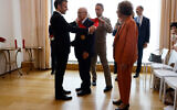 La journaliste franco-allemande et chasseuse de nazis Beate Klarsfeld regarde le président français Emmanuel Macron (G) remettre à son mari l'ordre du militant français et chasseur de nazis Serge Klarsfeld (2e G) lors d'une cérémonie à l'ambassade de France à Berlin, le 27 mai 2024. (Crédit : Ludovic MARIN / AFP)