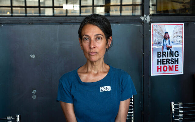 Rachel Goldberg-Polin, la mère de Hersh Goldberg-Polin, retenu en otage par le Hamas, pose pour une photo à côté d'une affiche de son fils lors d'une interview à Jérusalem le 29 mai 2024.  (Crédit : Ahikam SERI / AFP)