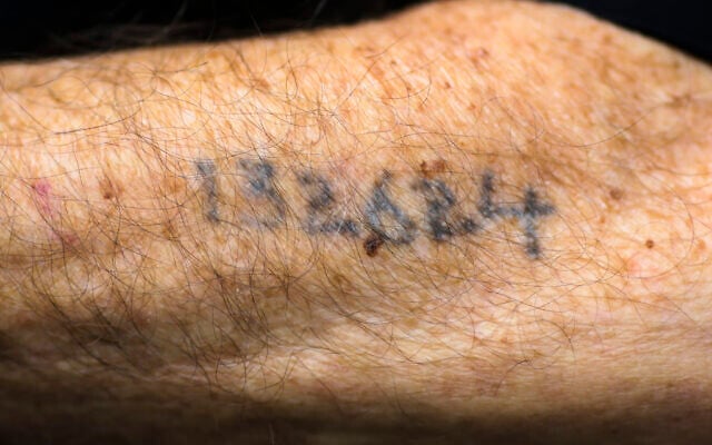 Photo d'illustration : Un survivant d'Auschwitz montre son numéro de tatouage à Lueneburg, en Allemagne, le 15 juillet 2015. (Crédit : AP Photo/Markus Schreiber, File) Photo d'illustration : Un survivant d'Auschwitz montre son numéro de tatouage à Lueneburg, en Allemagne, le 15 juillet 2015. (Crédit : AP Photo/Markus Schreiber, File)