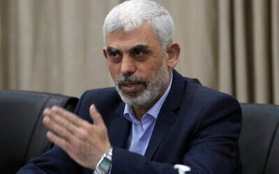 Yahya Sinwar, le chef du Hamas à Gaza, saluant ses partisans pendant une rencontre de factions palestiniennes, dans son bureau de Gaza City, le 13 avril 2022. (Crédit : Adel Hana/AP)