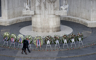 Le roi Willem-Alexander et la reine Maxima passent devant des gerbes déposées au monument national pendant la cérémonie de la Journée du Souvenir, en l'honneur des forces armées tuées dans des guerres et dans des missions de maintien de la paix depuis le début de la Seconde guerre mondiale, sur la place Dam, à Amsterdam, 4 mai 2022. (Crédit :  Koen van Weel/Pool Photo via AP)