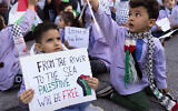 Un élève palestinien du primaire tient une pancarte sur laquelle on peut lire « Du fleuve à la mer, la Palestine sera libre » alors qu'il participe à un sit-in devant le bureau de la délégation de l'Union européenne au Liban, pour montrer sa solidarité avec le peuple palestinien à Gaza, à Beyrouth, au Liban, le 14 décembre 2023. (Crédit : AP Photo/Hussein Malla)