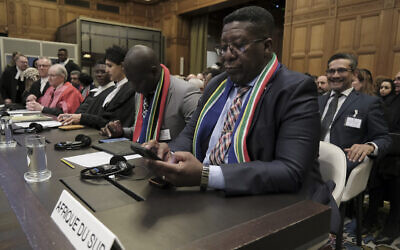 L'ambassadeur sud-africain aux Pays-Bas, Vusimuzi Madonsela, vérifie son téléphone pendant une audience devant la Cour internationale de Justice de La Haye, aux Pays-Bas, le 12 janvier 2024. (Crédit : Patrick Post/AP)