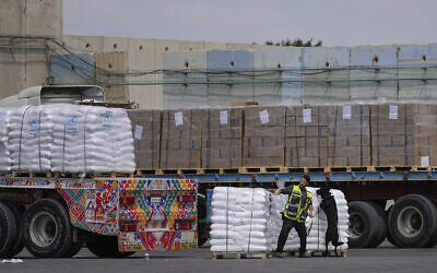 Des camions transportant de l'aide humanitaire en direction de la bande de Gaza passant par la zone d'inspection au passage de Kerem Shalom, dans le sud d'Israël, le 14 mars 2024. (Crédit : Ohad Zwigenberg/AP)
