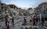 Les Palestiniens regardent les décombres après une frappe israélienne à Deir al-Balah, dans la bande de Gaza, le 30 avril 2024. (Crédit : AP Photo/Abdel Kareem Hana)