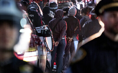 Des policiers de la ville de New York arrêtant des personnes, après qu'un bâtiment occupé par des manifestants plus tôt dans la journée a été libéré, ainsi qu'un campement de tentes près du campus de l'Université Columbia, à New York, le 30 avril 2024. (Crédit : Craig Ruttle/AP)