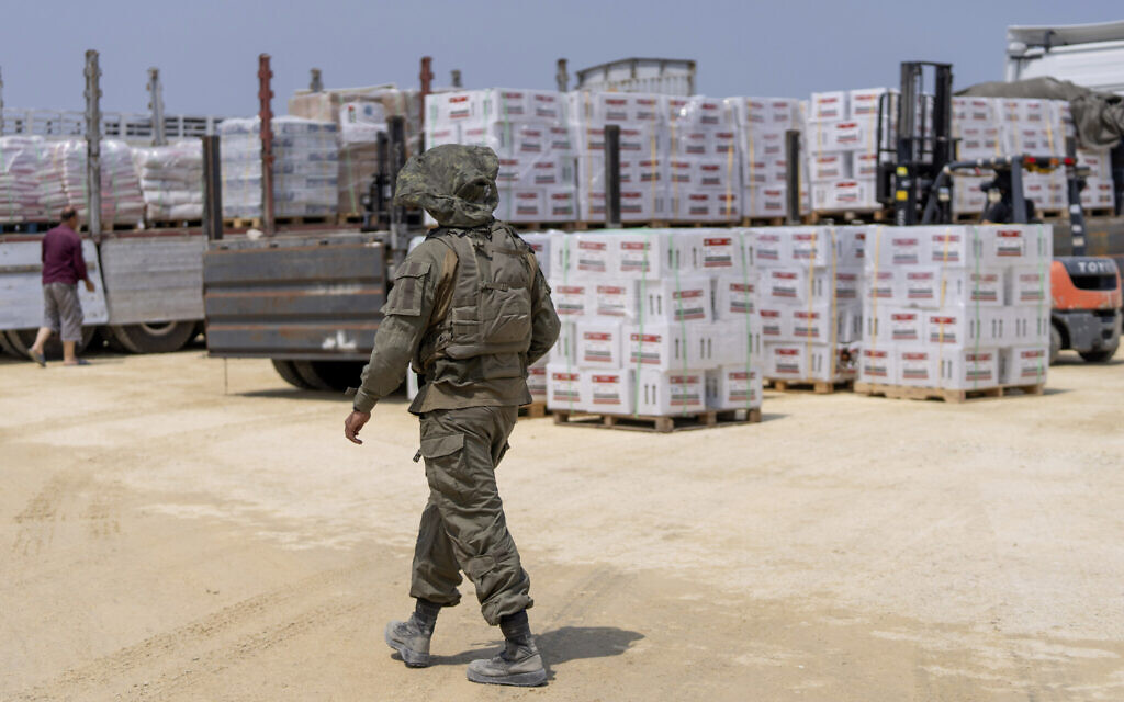 Un soldat de Tsahal traverse une zone d'inspection de camions transportant de l'aide humanitaire à destination de la bande de Gaza, du côté palestinien du point de passage d'Erez, dans le sud d'Israël, le 1er mai 2024. (Crédit : AP Photo/Ohad Zwigenberg)